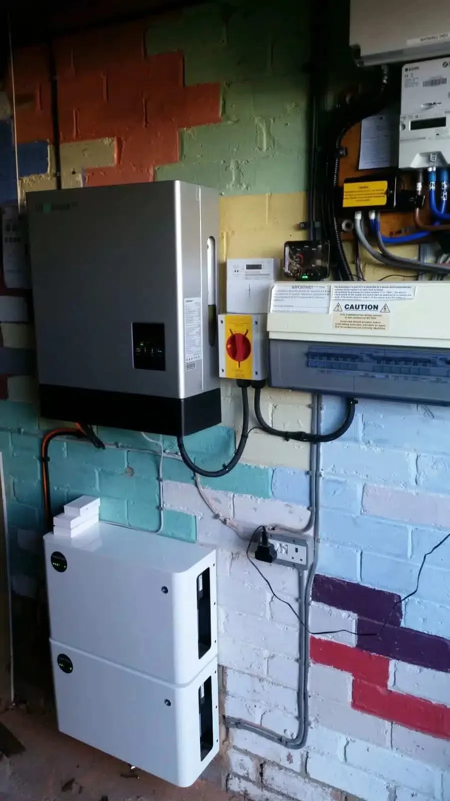Solar battery storage and inverter system installed in a garage, featuring a wall-mounted inverter, battery unit, and electrical control equipment designed to maximise solar energy usage and reduce grid reliance.