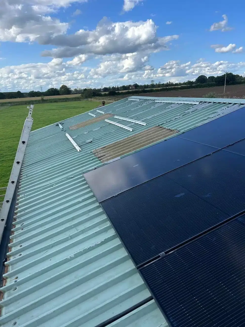 Solar panels mounted on a trapezoidal warehouse roof, providing renewable energy for commercial operations.