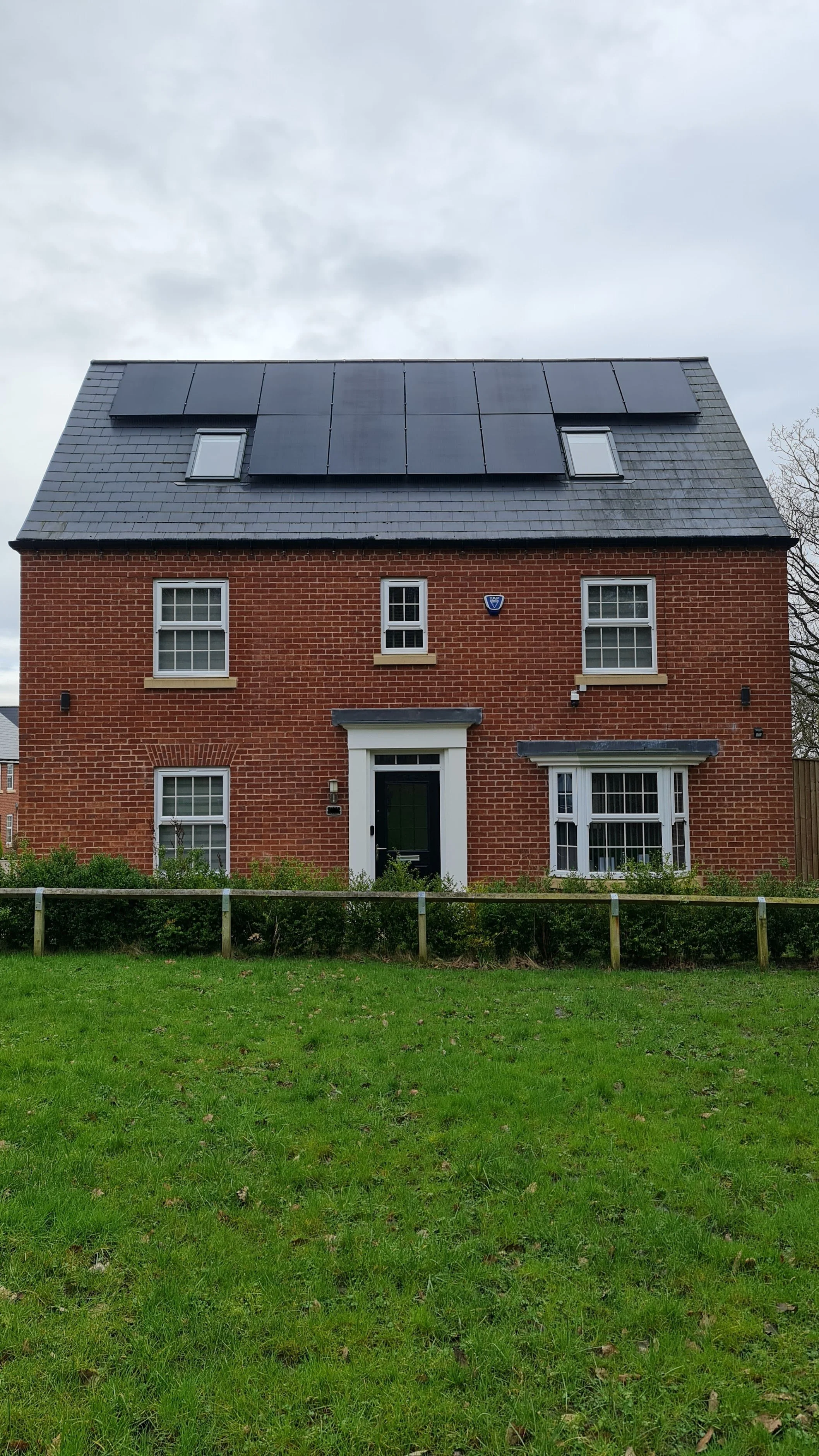 Detached red brick home in Lancaster with in-roof solar panel installation