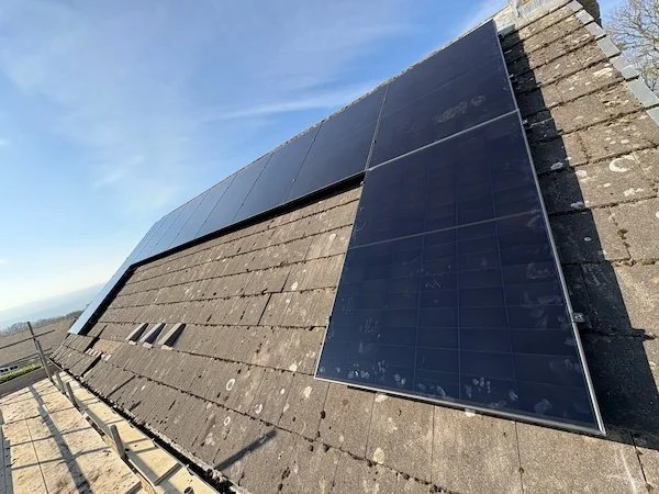 Aerial view of solar panels installed along a slate roof ridge, Bingley and Keighley area