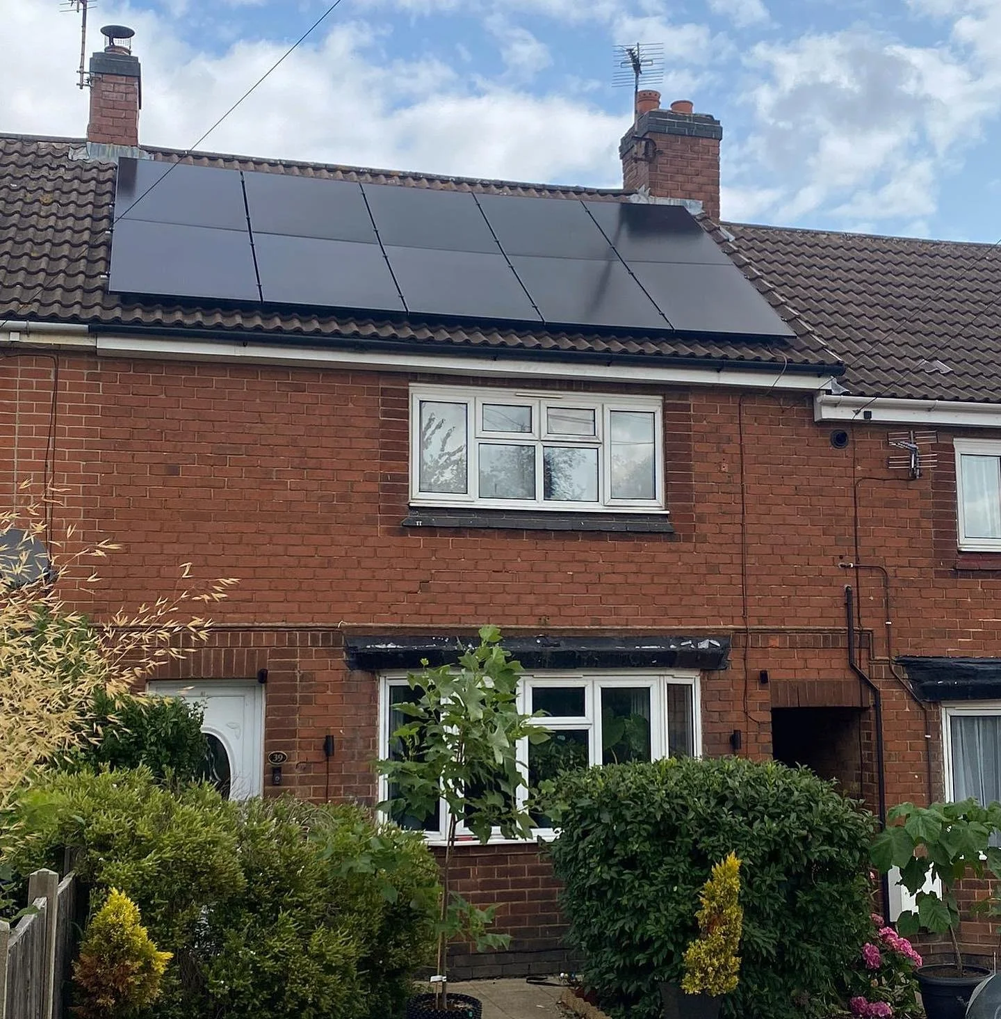 Brick semi-detached house with solar panels installed on the roof