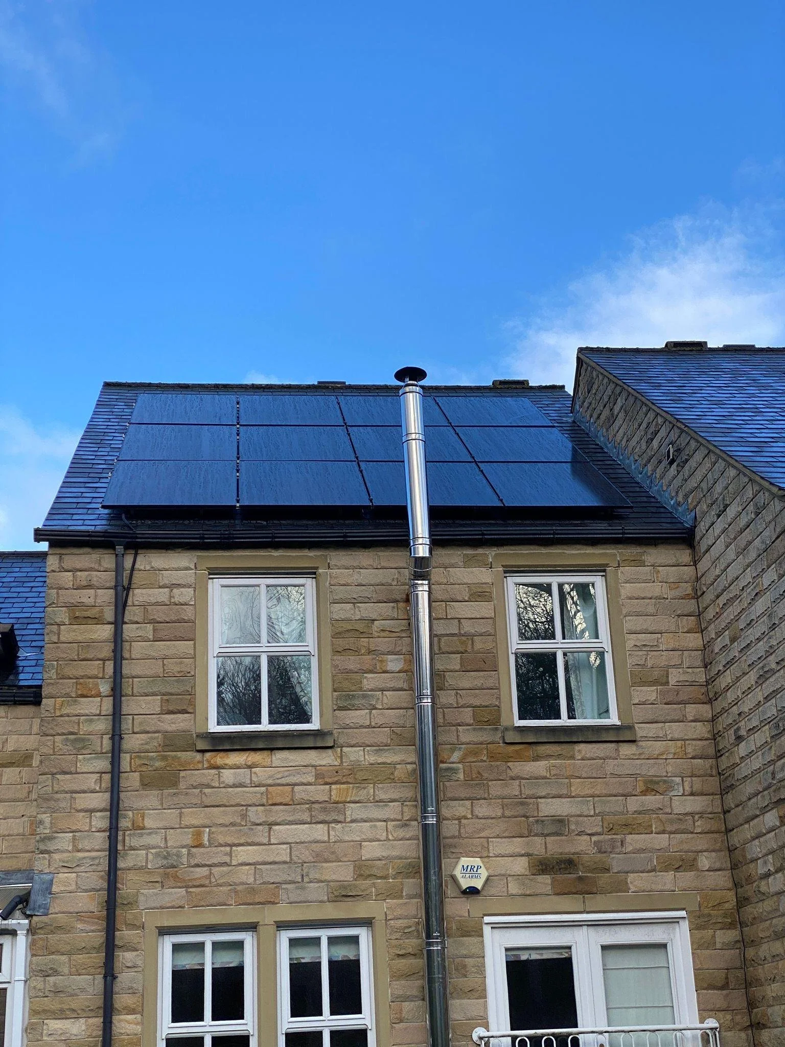Solar panels installed on the roof of a stone terraced house, Ilkley and Bradford area