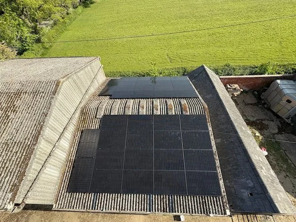 Aerial view of solar panels installed across an agricultural building roof, Harrogate area
