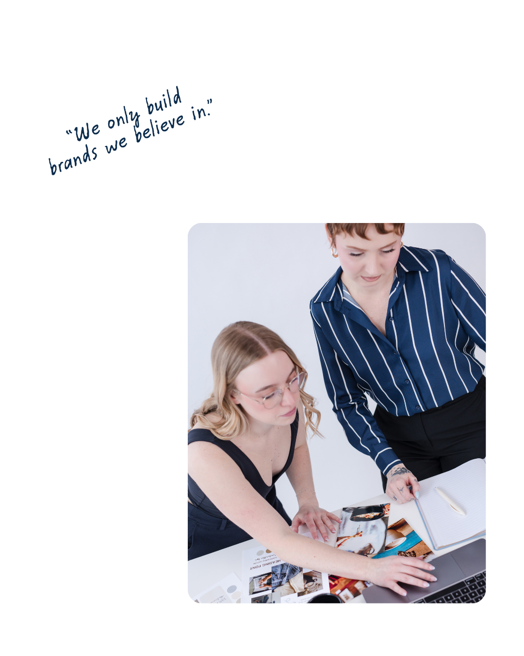 Two women looking at a computer with brand mood boards on the table