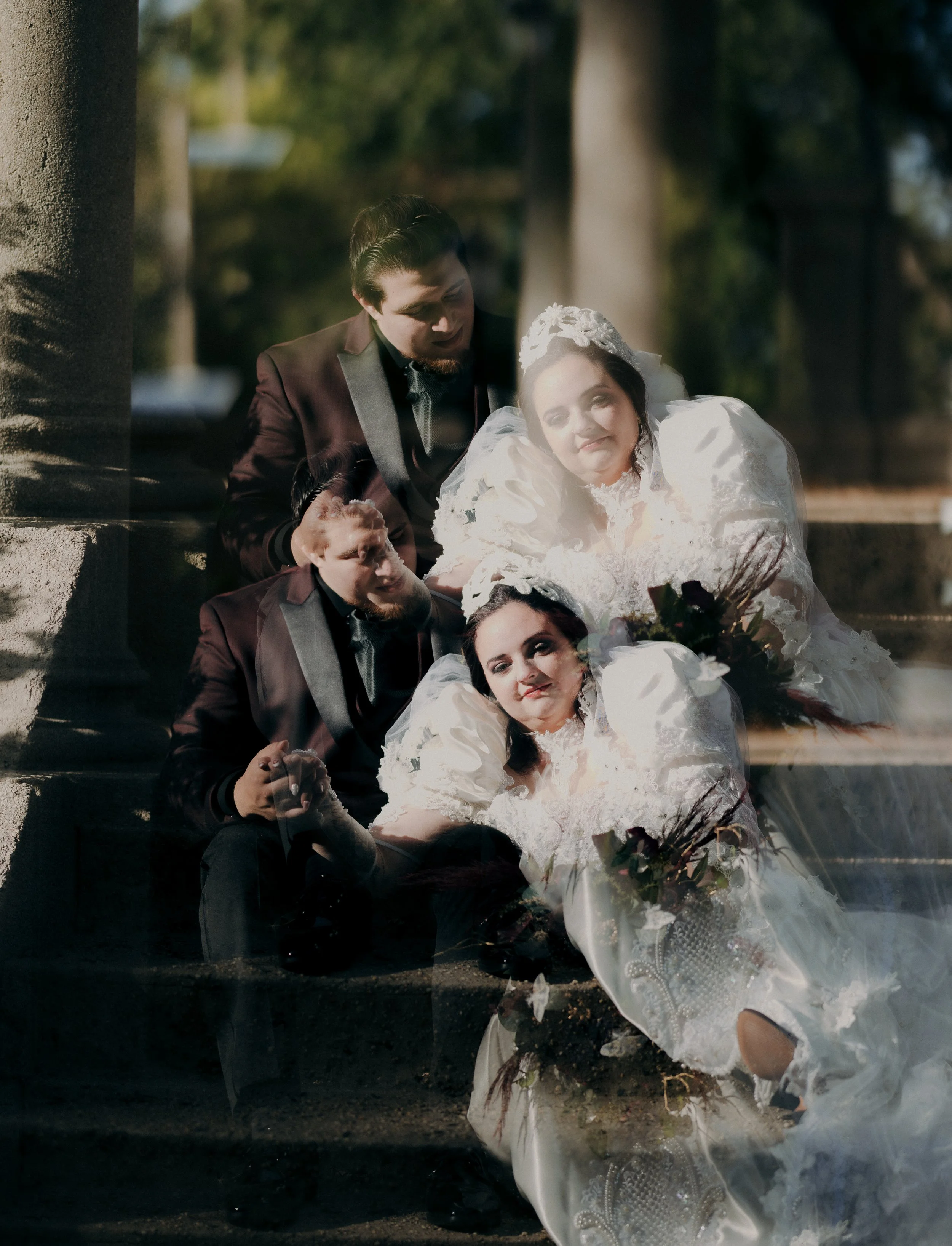 A wedding photo of a bride and groom seated on stairs outdoors, with the image doubling and creating a layered effect.