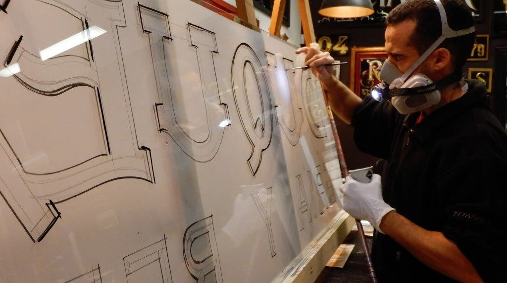 Para el pintado del rótulo superior, calcamos el diseño del original, y usamos este calco de guía para trazar las letras en nuestros nuevos cristales, laminados para mayor seguridad.