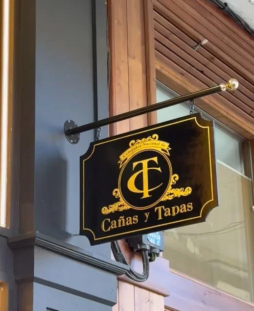 Baderola de madera y poste dorado en la fachada de Cañas y Tapas Burgos por Rotulacion a mano