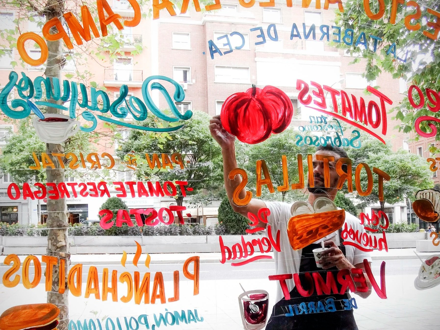 Rotulista pintando sobre el escaparate de un bar lettering o rotulacion a mano Madrid
