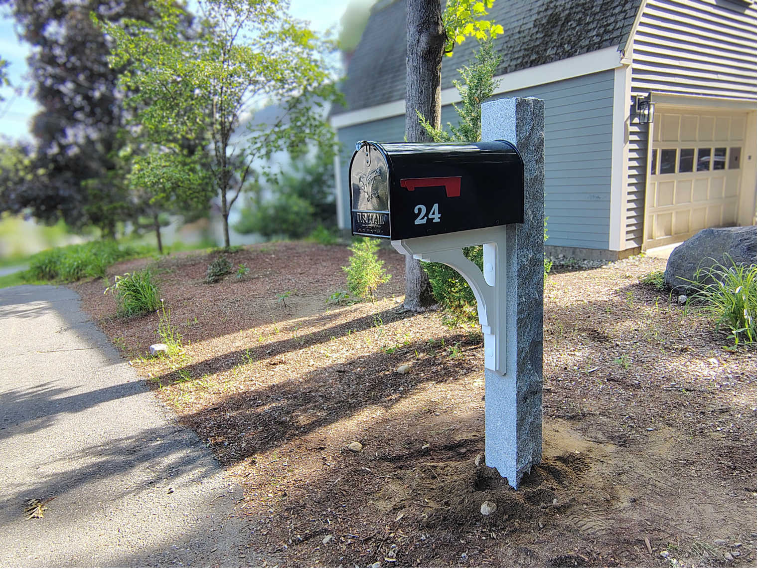 6x6 granite mailbox post fully installed by mailbox doctor , with a white wood bracket and black mailbox