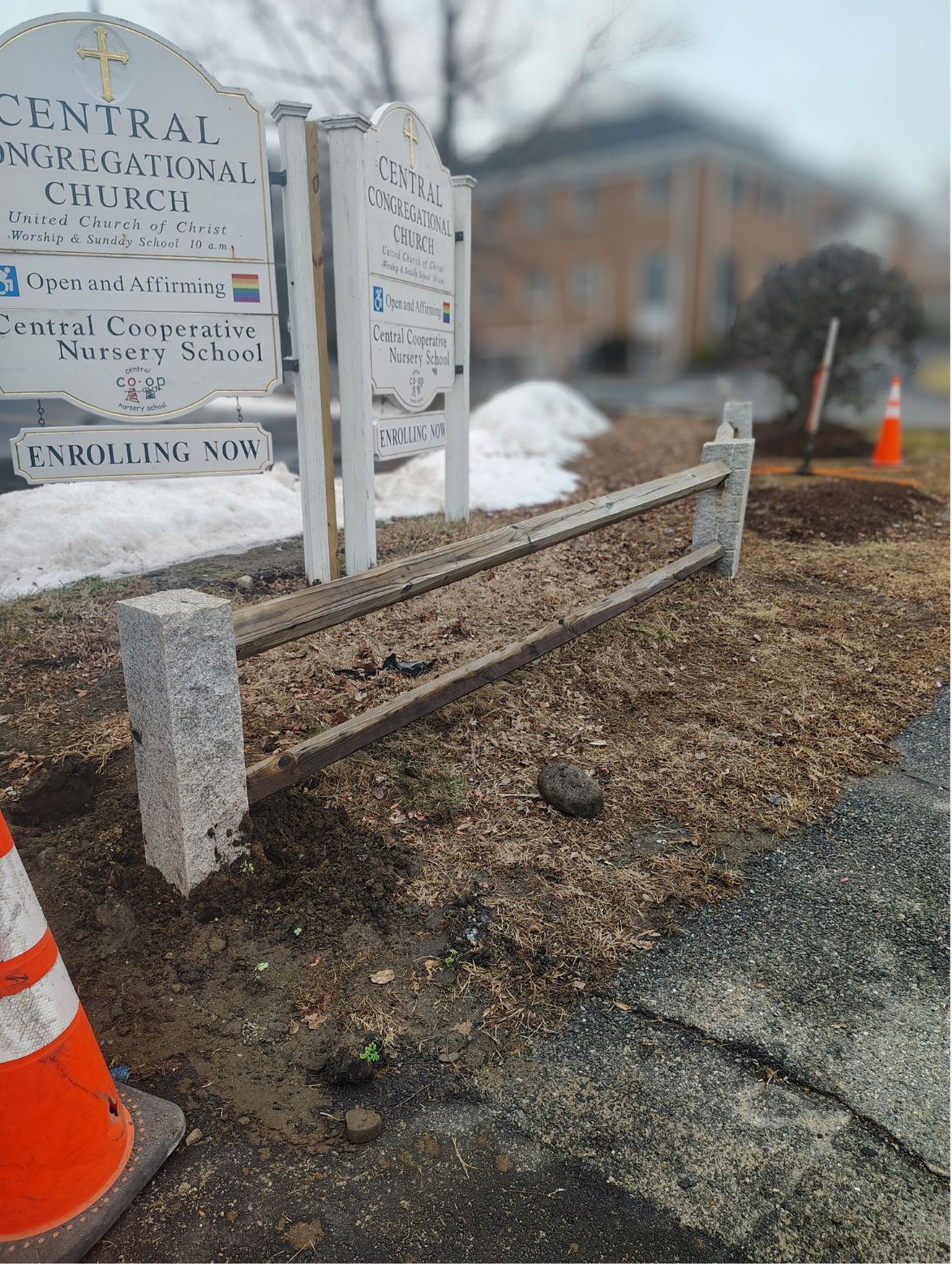 Two signs for Central Congregational Church and Central Cooperative Nursery School with snow on the ground and a wooden fence being installed in the foreground.