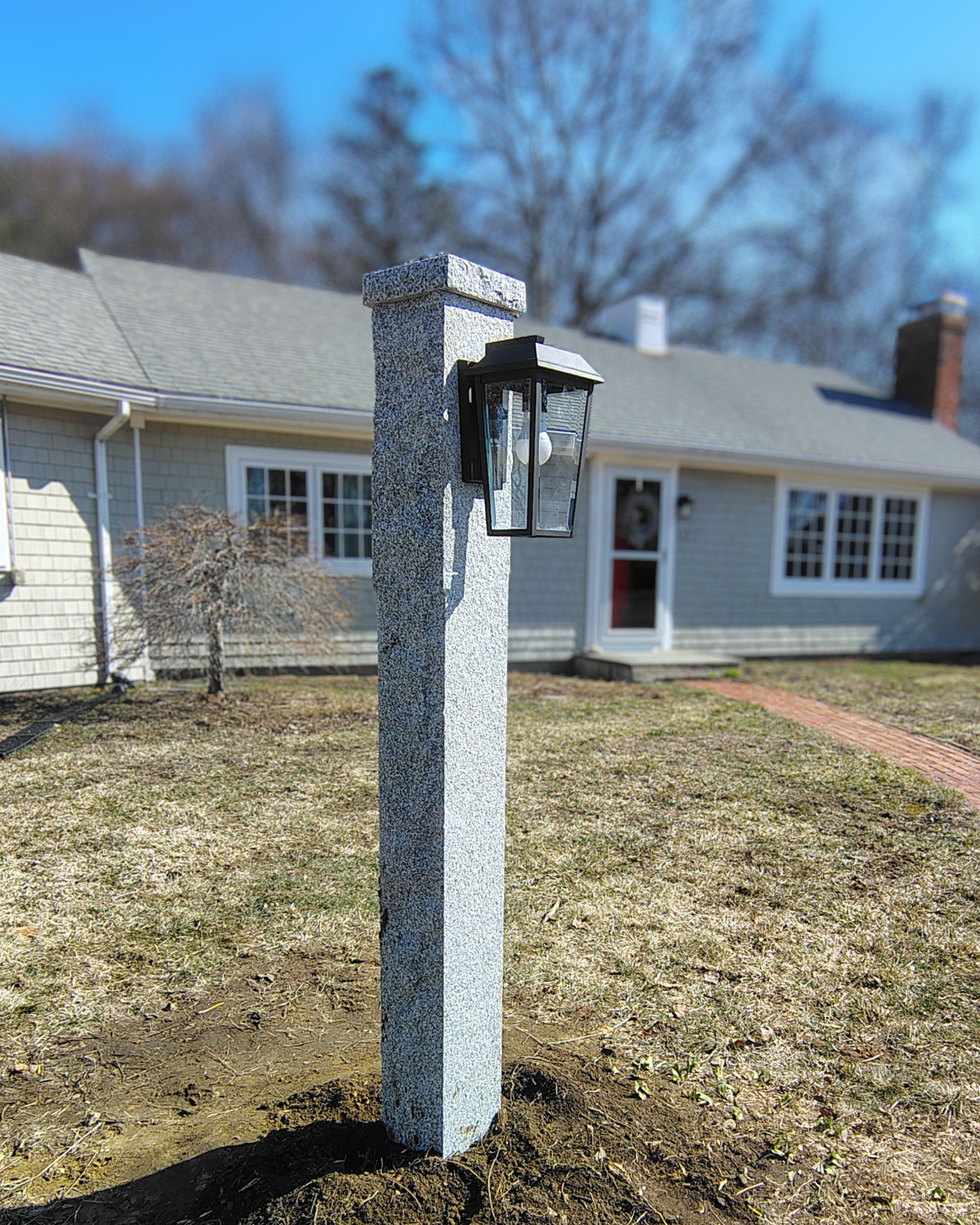 Granite lamppost with flat cap and side mounted lamp fully installed by mailbox doctor