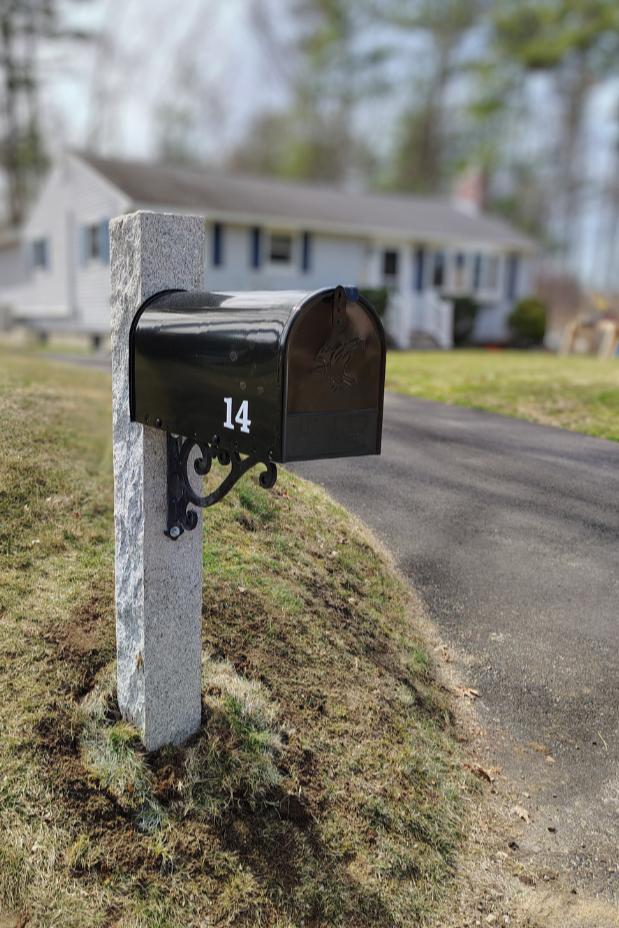 Granite mailbox post with black decorative bracket and matching black Gibraltar  mailbox . Acton Massachusetts
