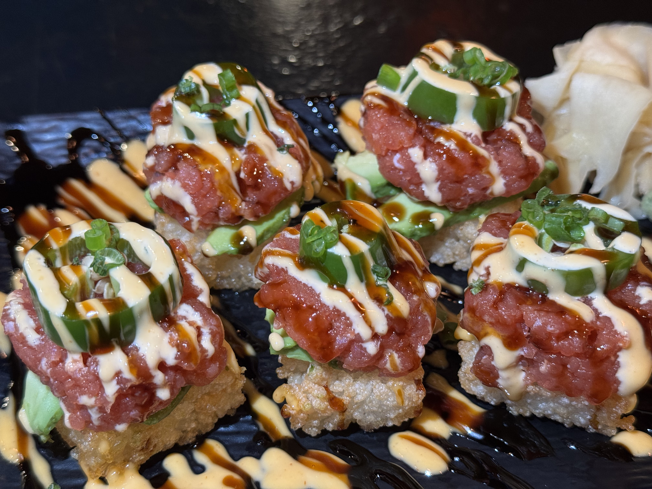 Crispy Chili Bombs - crispy sushi rice topped with spicy tuna, avocado, jalapeńo, spicy mayo, eel sauce & scallion