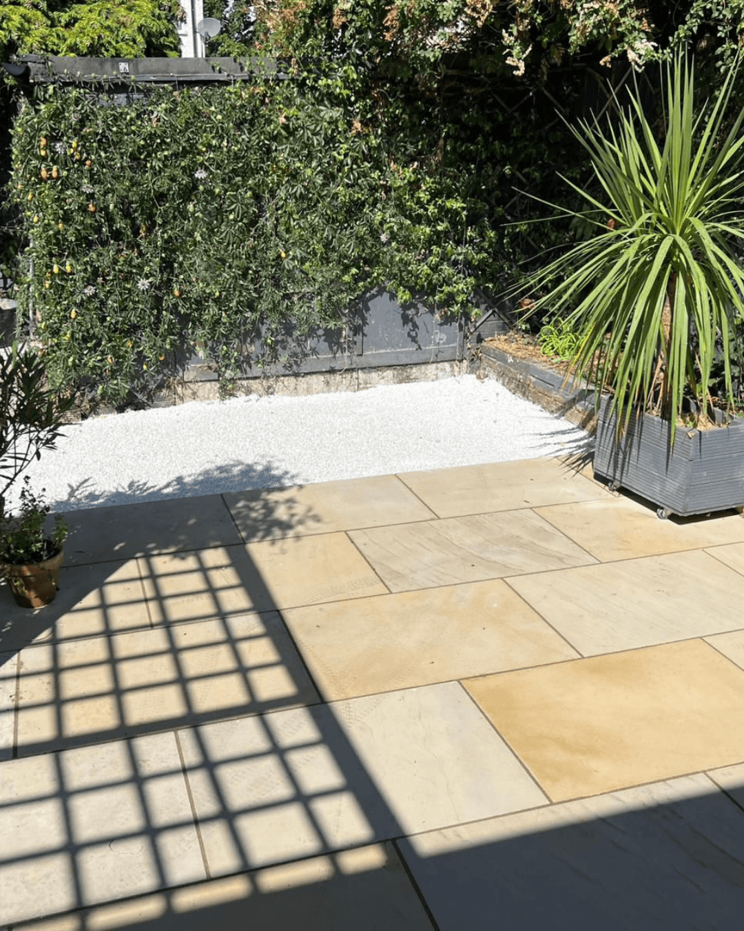 Sandstone garden patio with decorative white gravel and planting in a landscaped Wimbledon, London garden.
