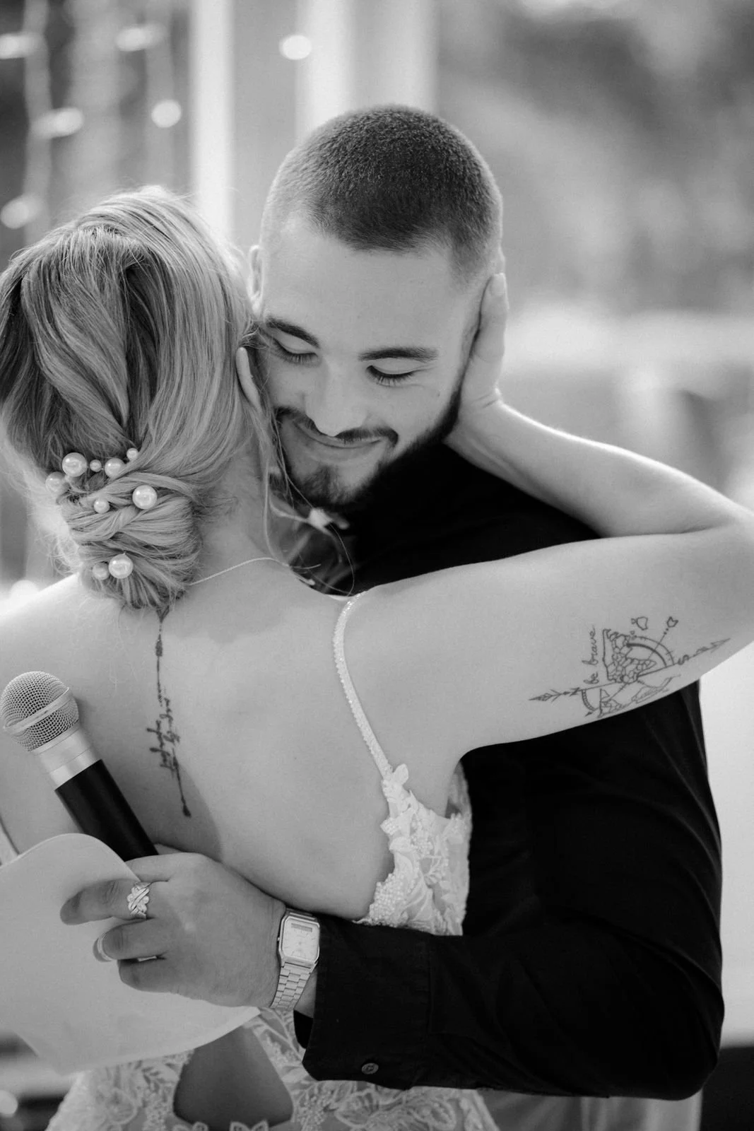 Ein glückliches Paar bei einer Umarmung bei einer besonderen Gelegenheit, möglicherweise eine Hochzeit, in einem Innenraum mit Dekorationen im Hintergrund. Die Hochzeit findet in Düsseldorf im Schloss Benrath statt. 