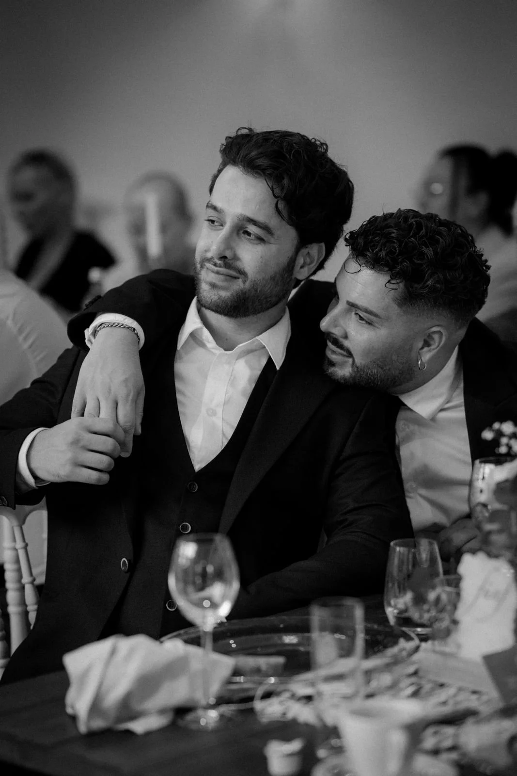 Zwei Männer in formeller Kleidung umarmt bei einer Hochzeitsfeier. Die Hochzeit findet in Düsseldorf, Nähe Köln statt. 