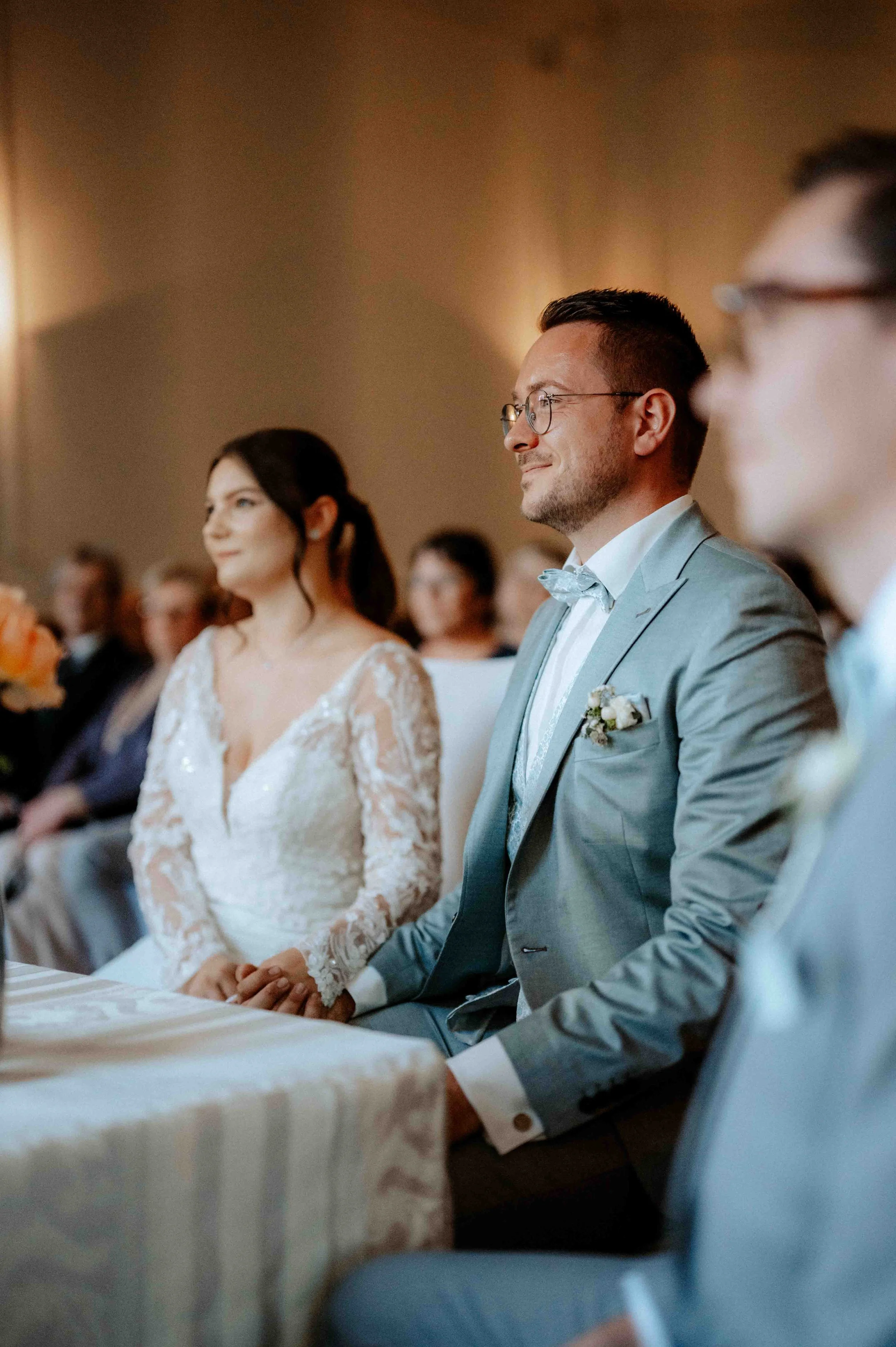 Hochzeitszeremonie mit Braut, Bräutigam und Gästen, die auf einem Stuhl sitzen. Die Hochzeit findet im Schloss Eicherhof in Leichlingen bei Düsseldorf, Nähe Köln statt. 