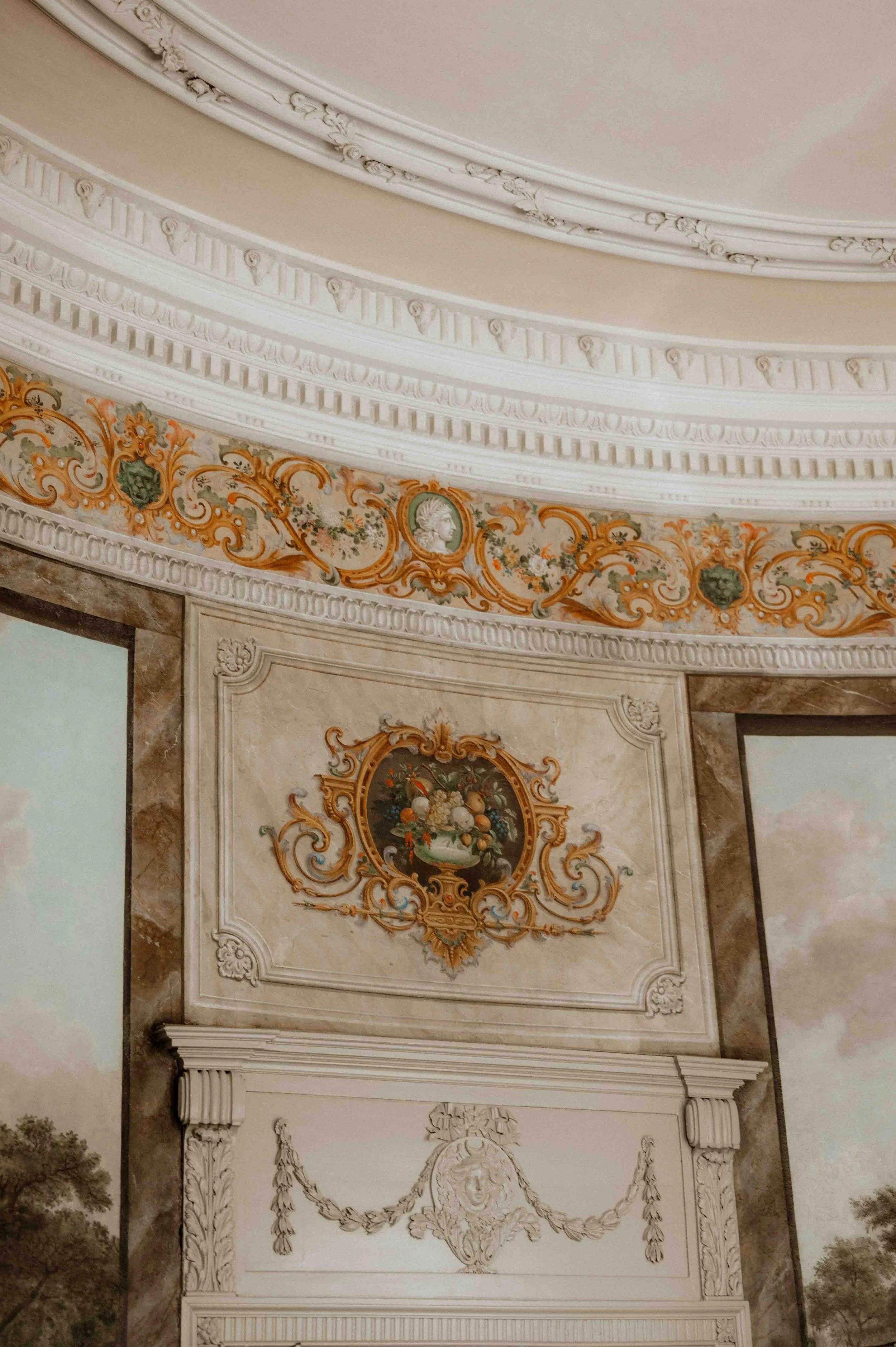 Decke und Wandverzierung in einem eleganten, klassischen Raum mit barockartigem Dekor, farbigem Blumenmosaik und einer Deckenlücke mit kunstvollen Verzierungen. Die Hochzeit findet in Düsseldorf, Nähe Köln statt. 