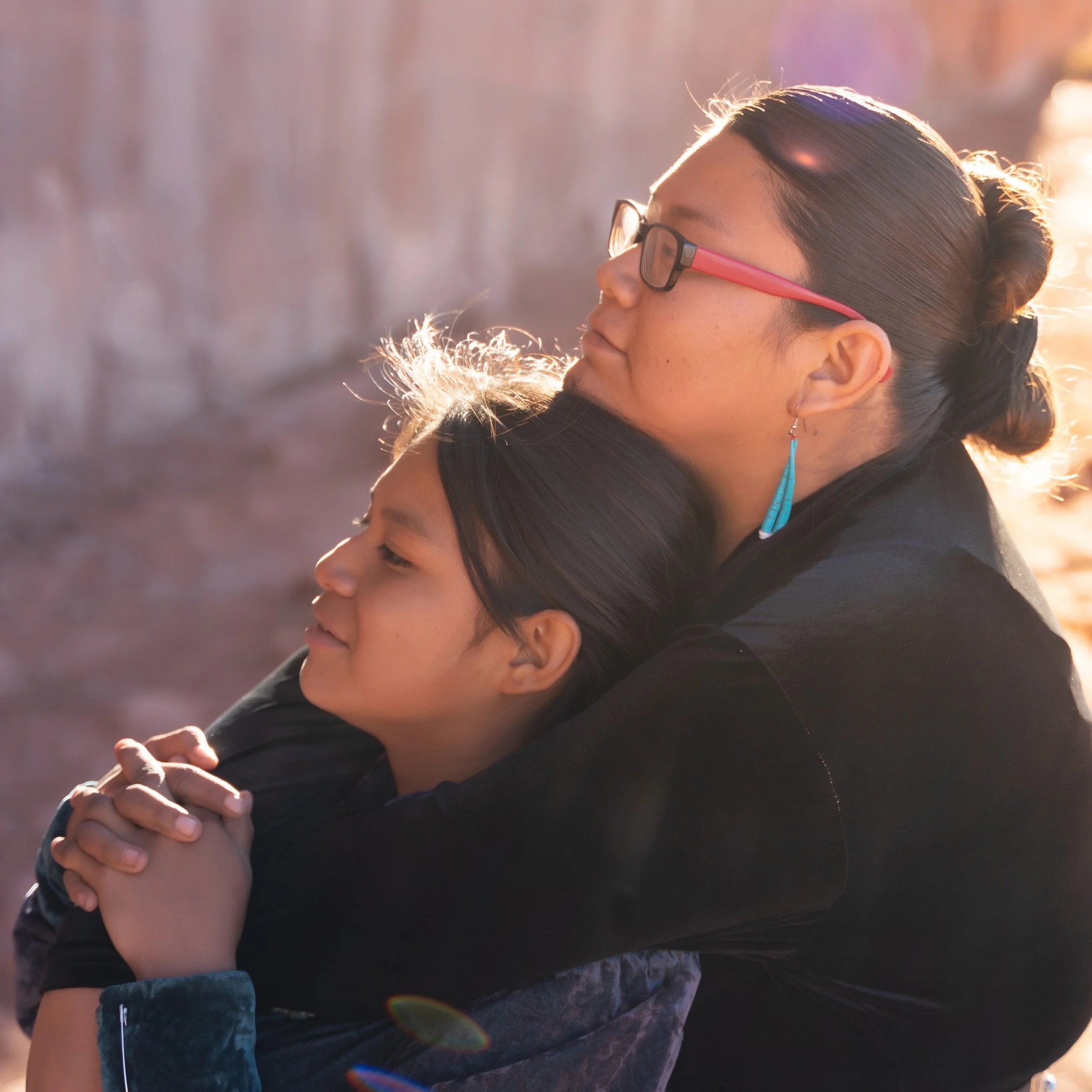 Mother hugging her daughter.