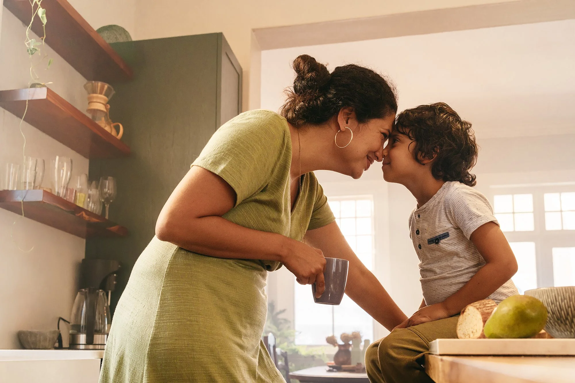Mother and sun enjoying a happy moment together in the kitchen.