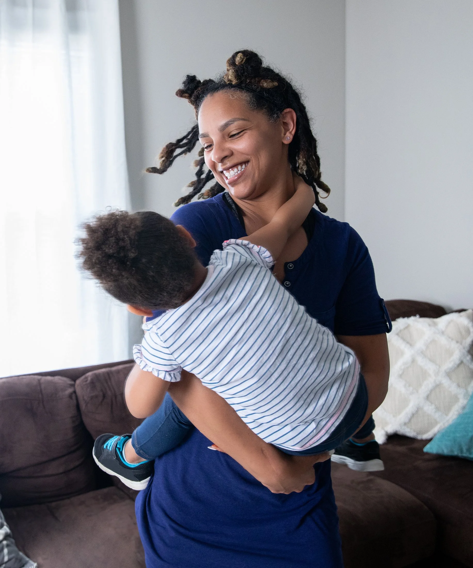 Smiling mother playing with her young son.