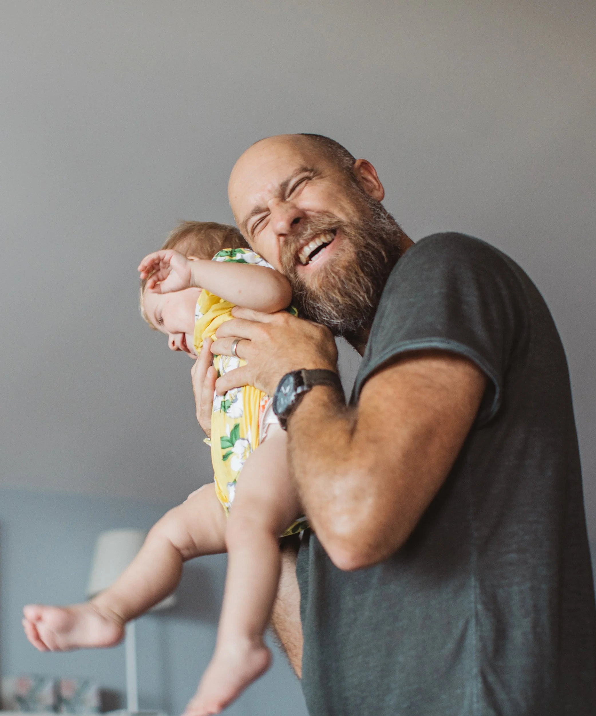 Smiling father playing with their young child.