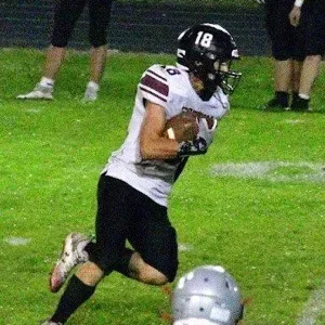 Football player running with the ball on a field
