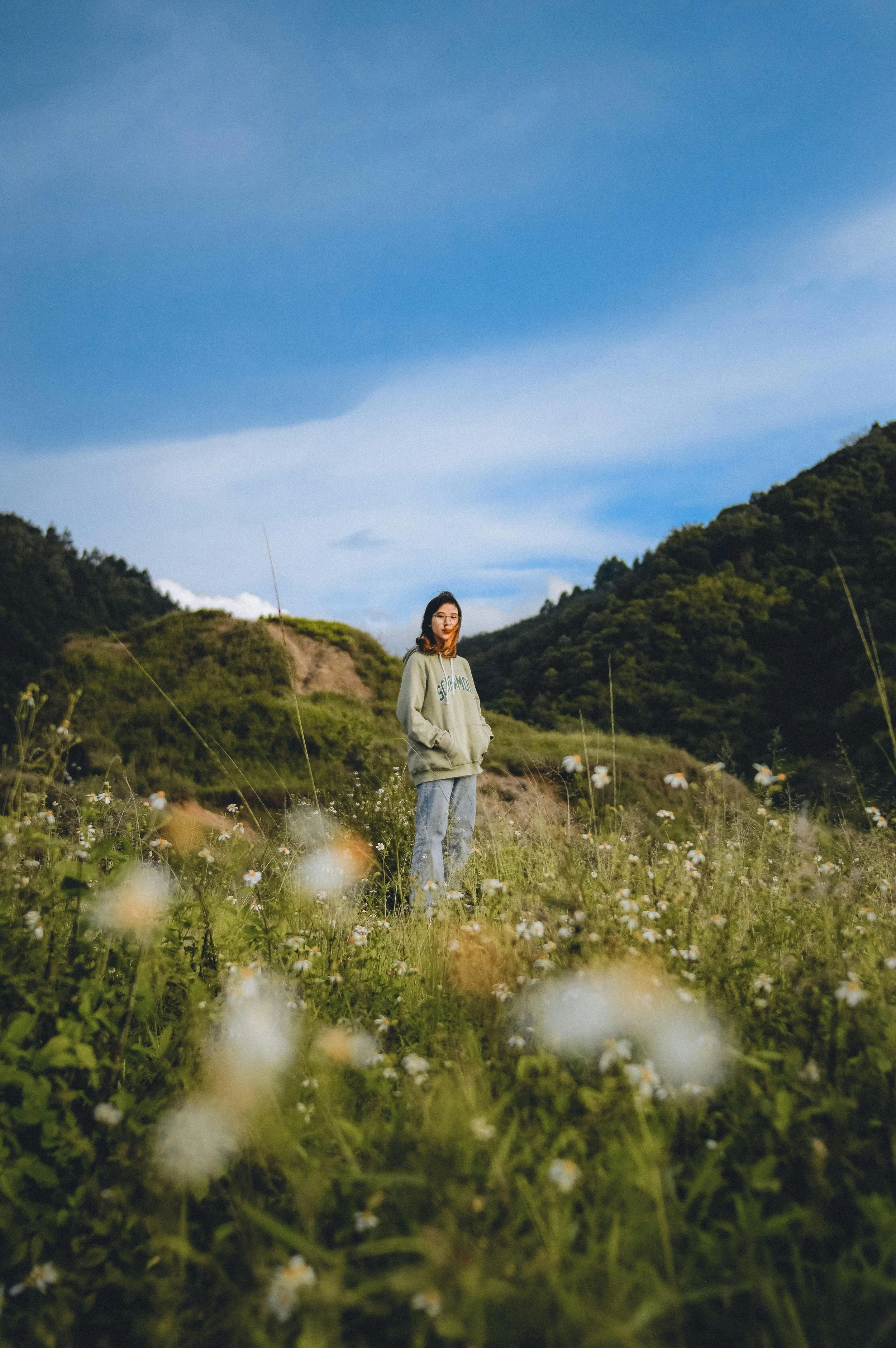 young woman standing in a wildflower field