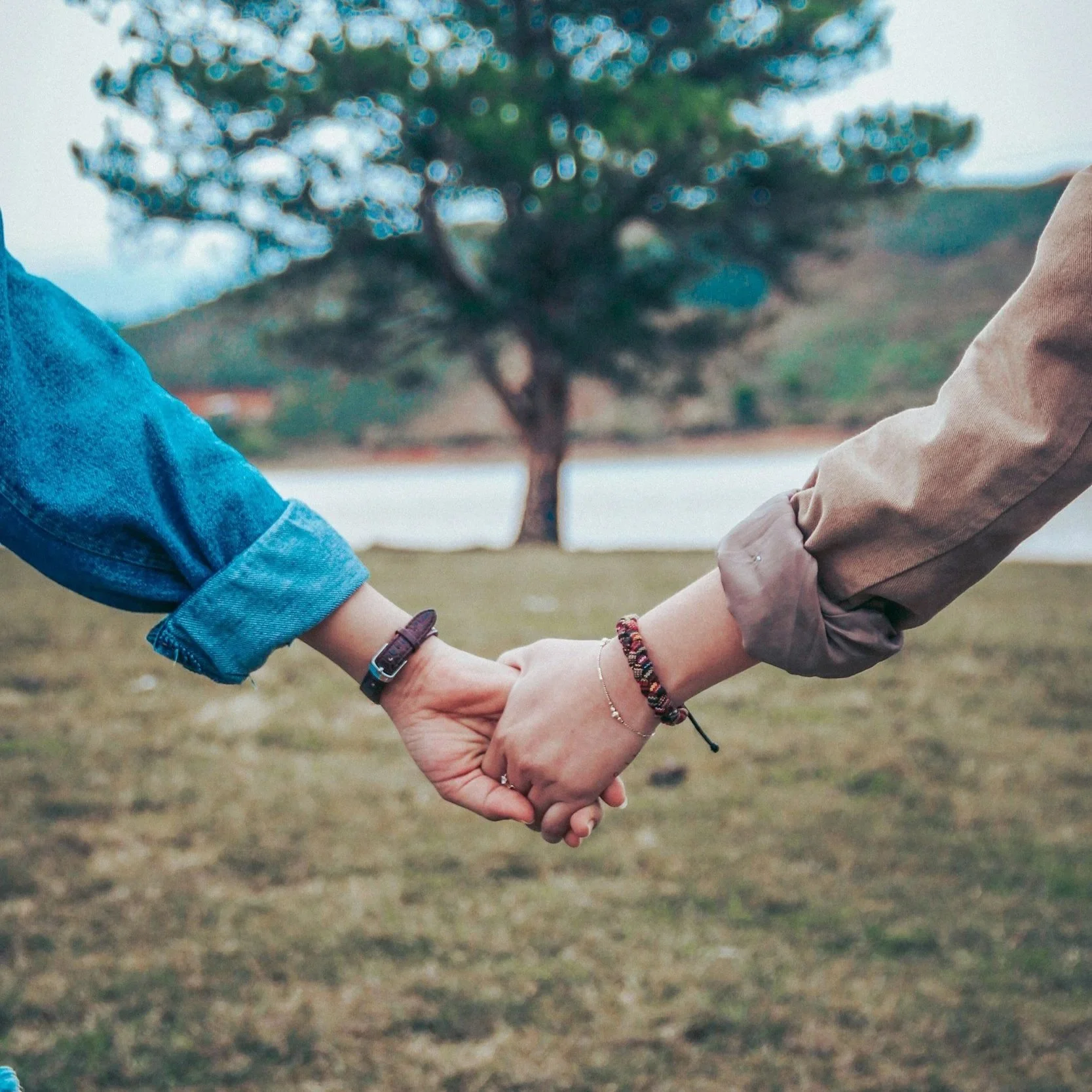 two people holding hands outdoors