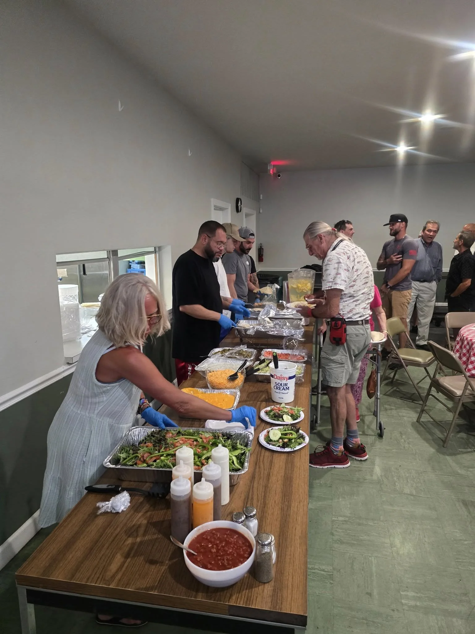 People serving and getting food at a buffet table