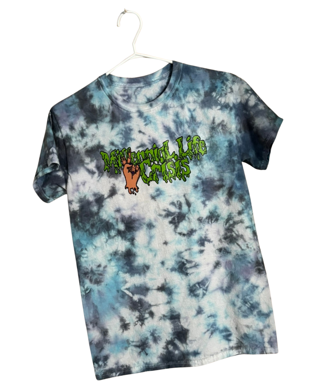 Tie-dye t-shirt with a graphic and text reading "Millennial Life Crisis" in dripping green font and a hand making a peace sign.