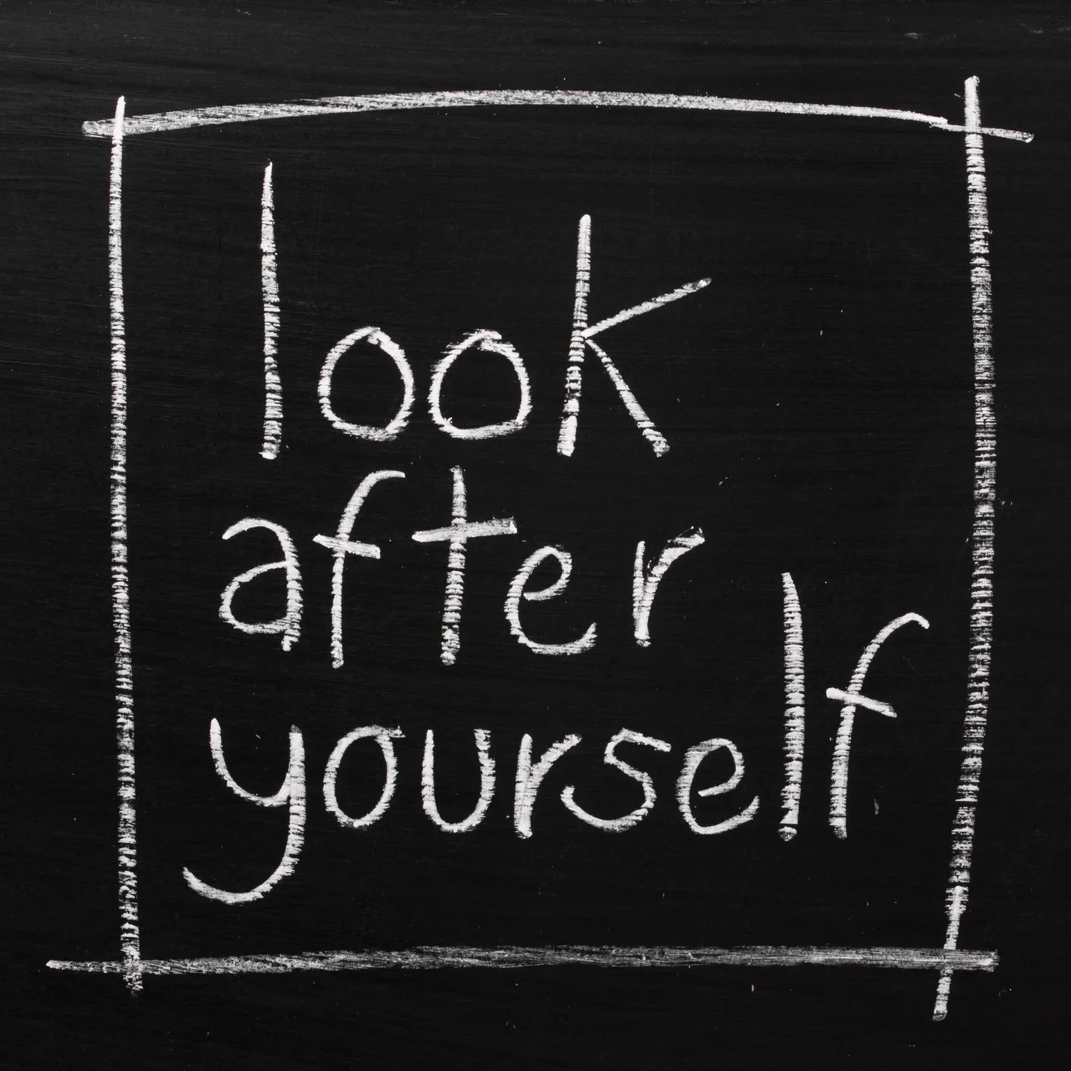 Chalkboard with white chalk writing that says "look after yourself"