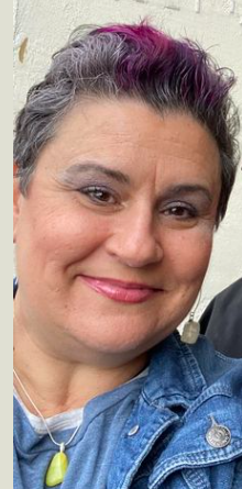 woman with salt and pepper and pink short hair, smiling