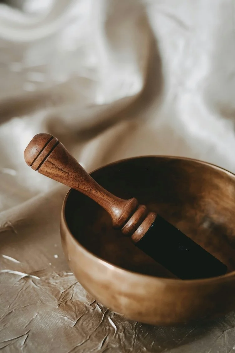 Singing bowl on a light tan background