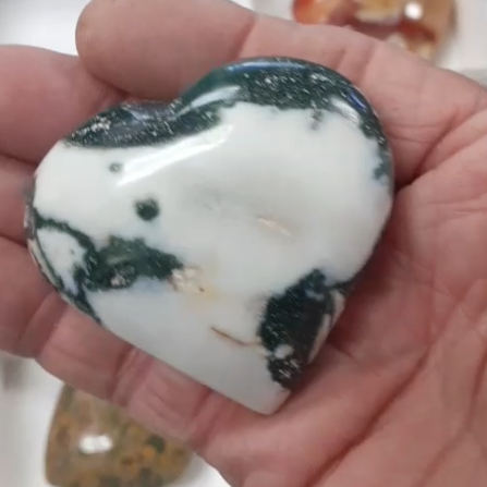 ocean jasper heart crystal in a woman's hand