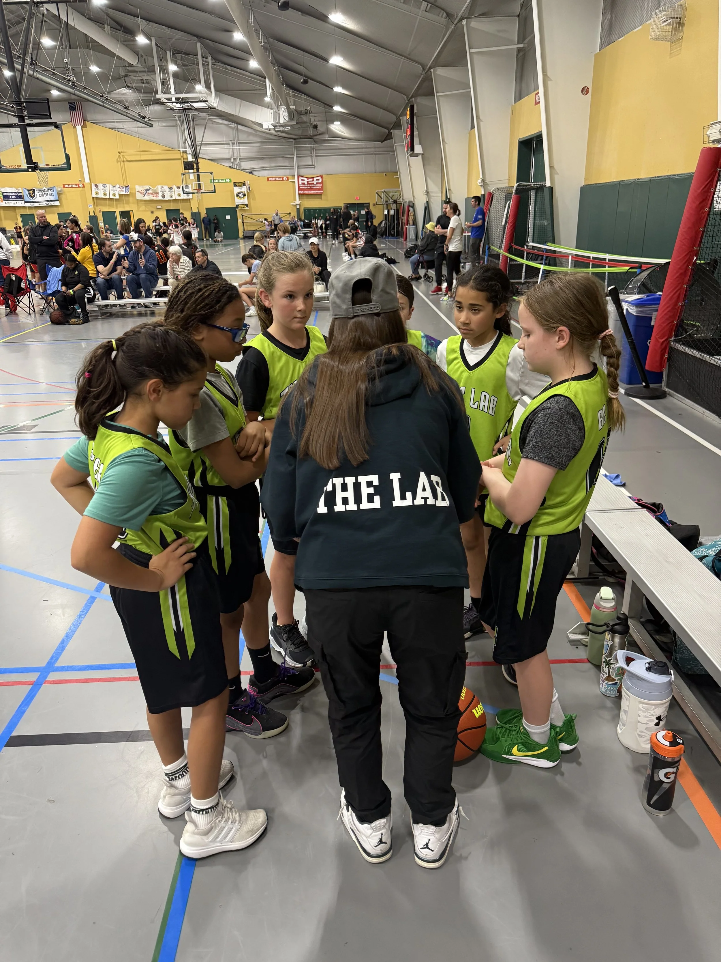 Group of young girls wearing yellow basketball jerseys with