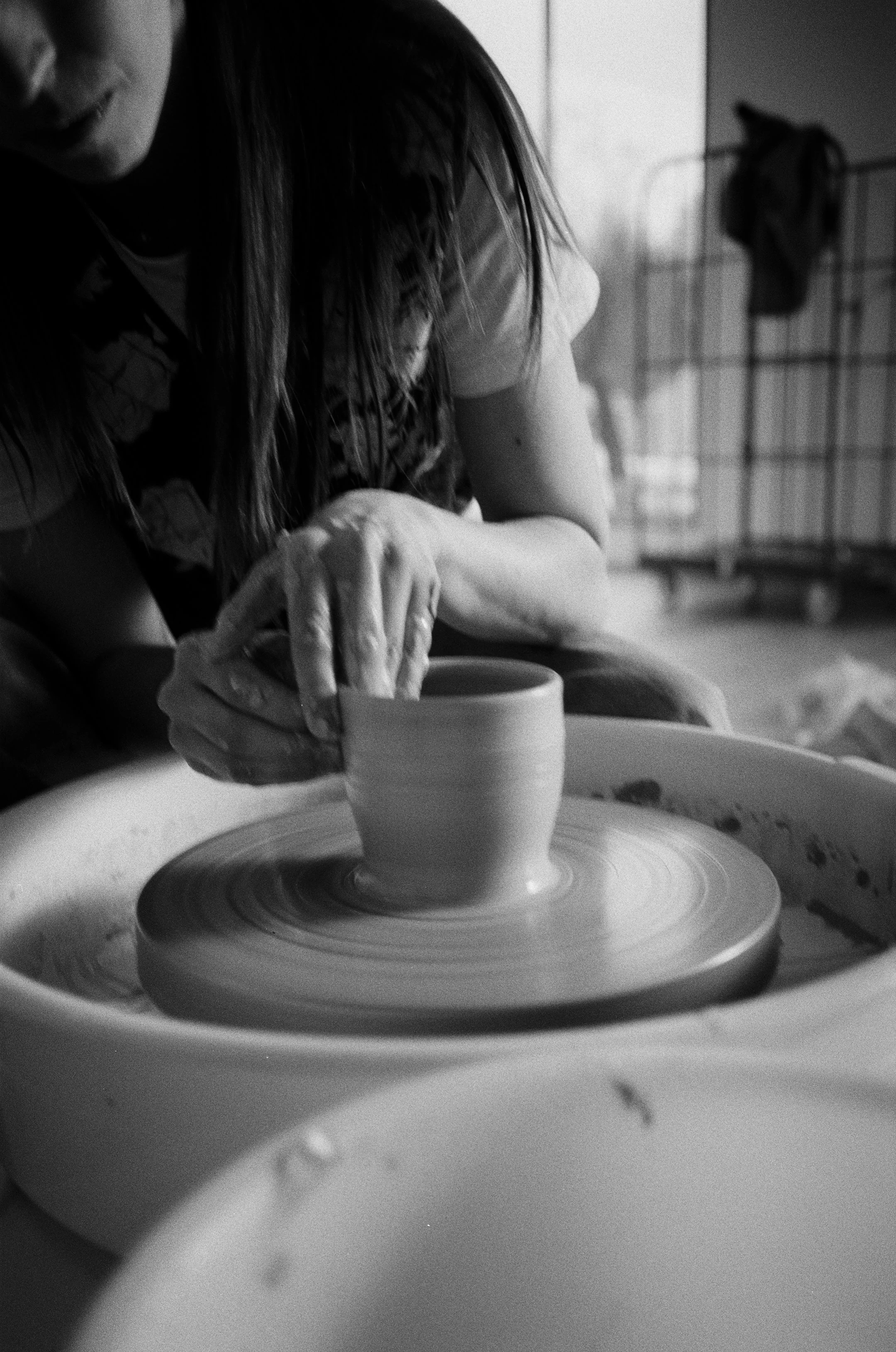 Person beim Töpfern auf der Töpferscheibe, Schwarz-Weiß-Fotografie