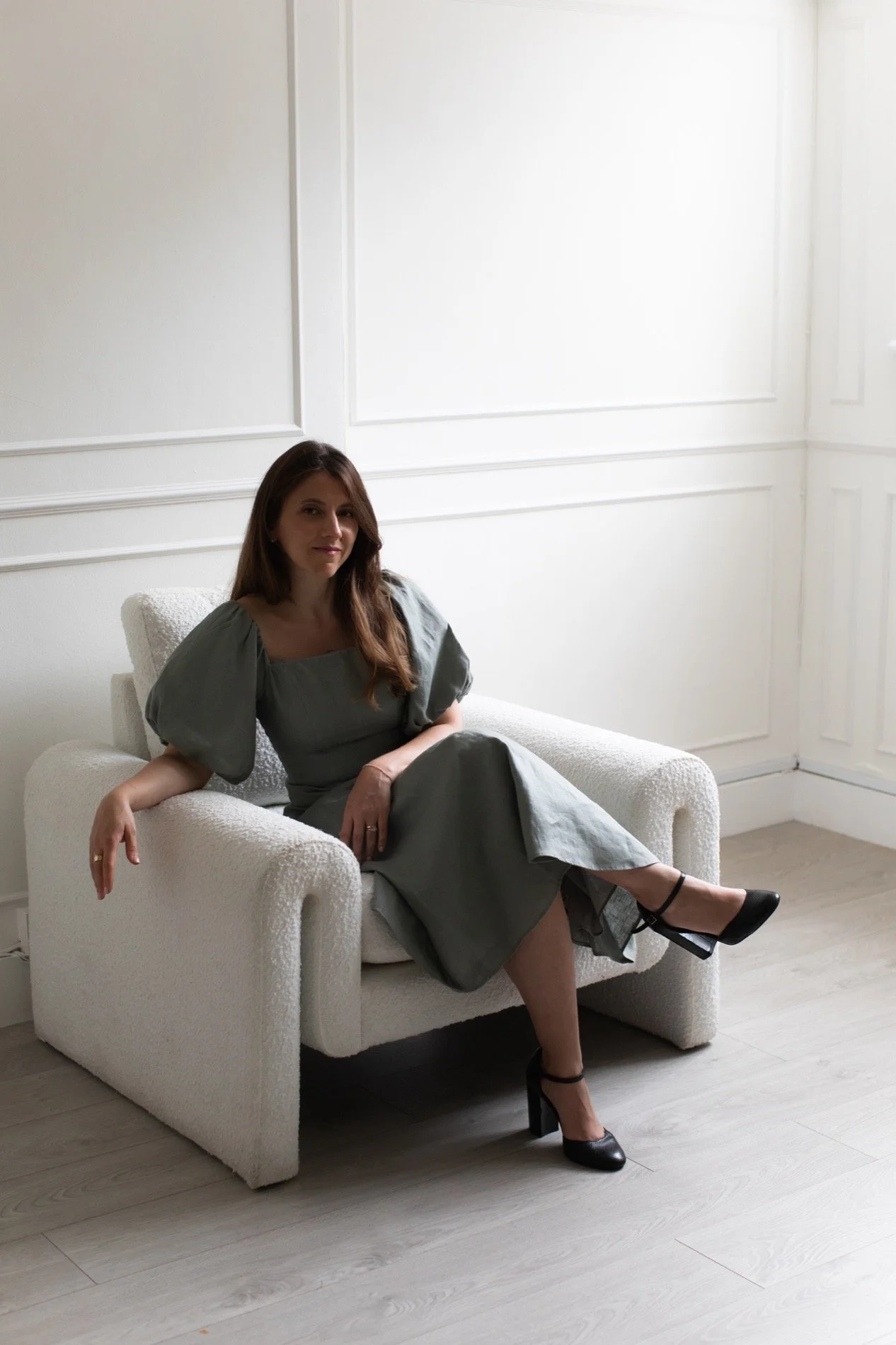 Nergis Yuksel, wedding SEO consultant sitting on an armchair at a London studio