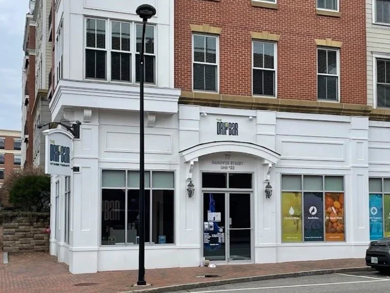 Exterior of a building with a sign for The Draft Bar, a business specializing in CBD and THC products, located on Santana Street. The building has large windows and a white facade on the ground level.