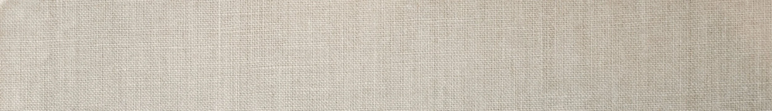 Close-up of a beige fabric surface with a subtle woven pattern.