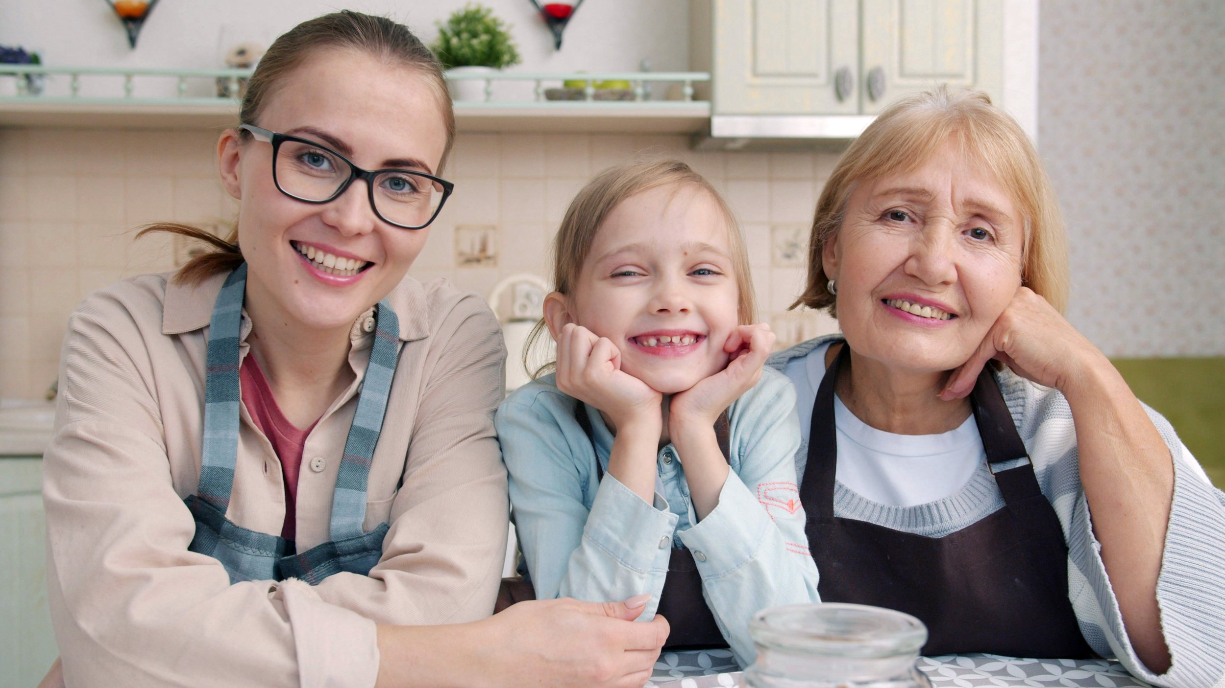 Three generations of women smiling together in a kitchen, representing family preparedness and planning.