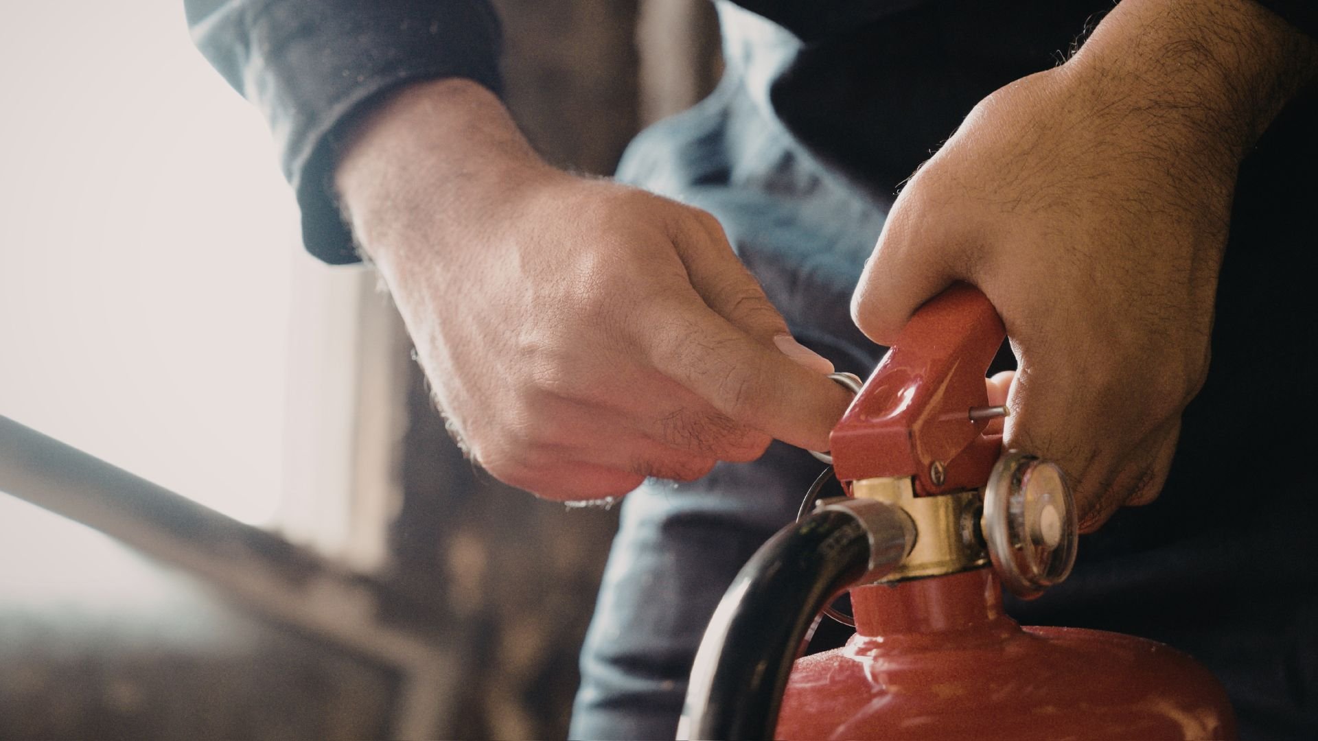 Hands filling a red gas can with a fuel nozzle.