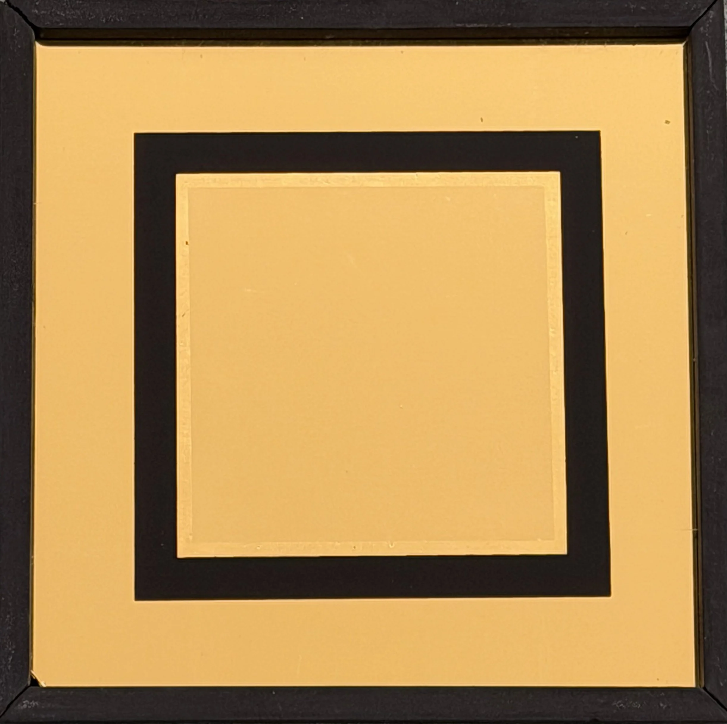 A gold-colored square with a black border, featuring nested squares of alternating gold and black colors.