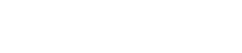 A black and white photo of a person riding a motorcycle on a street in a city.