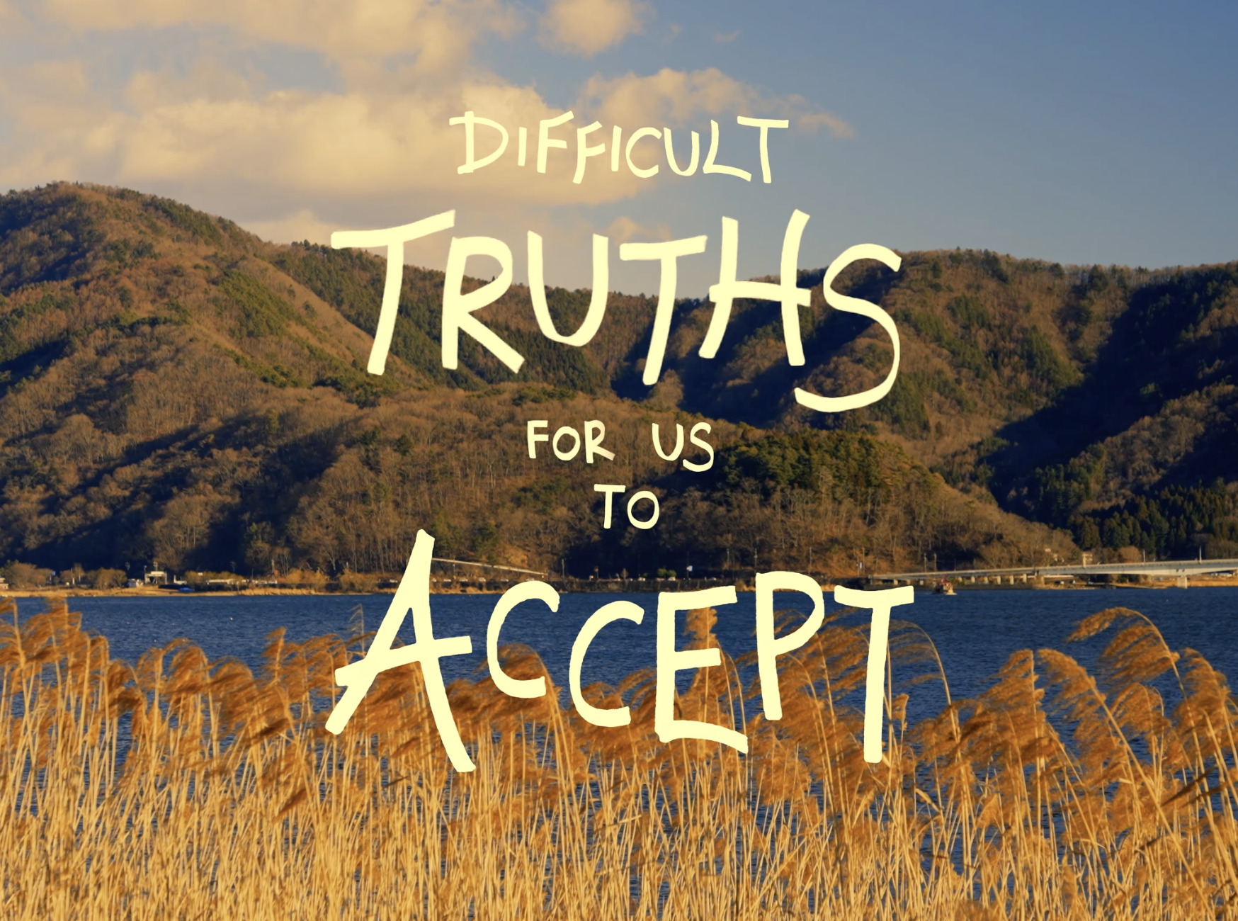 A scenic landscape with mountains, water, and tall golden grass, with the text 'Difficult Truths for Us to Accept' overlaid.