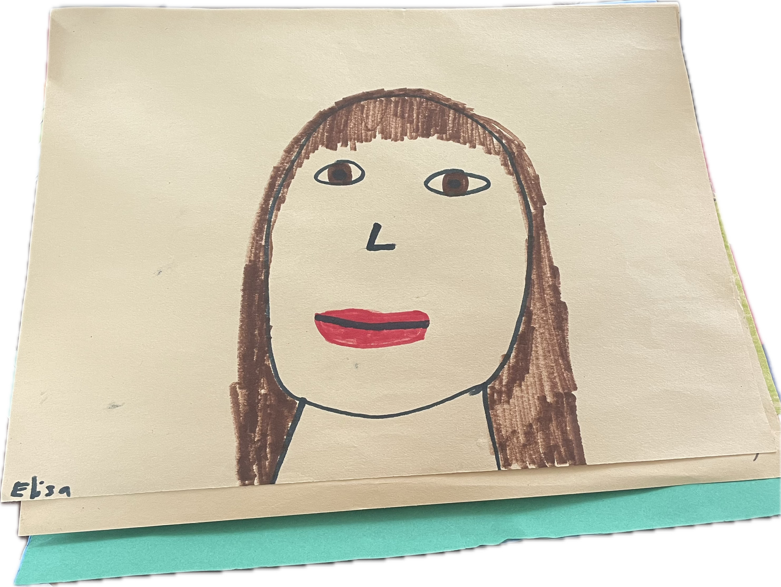 Child's drawing of a person's face with brown hair, two eyes, a small nose, and red lips, signed 'Elsa' in the bottom left corner.