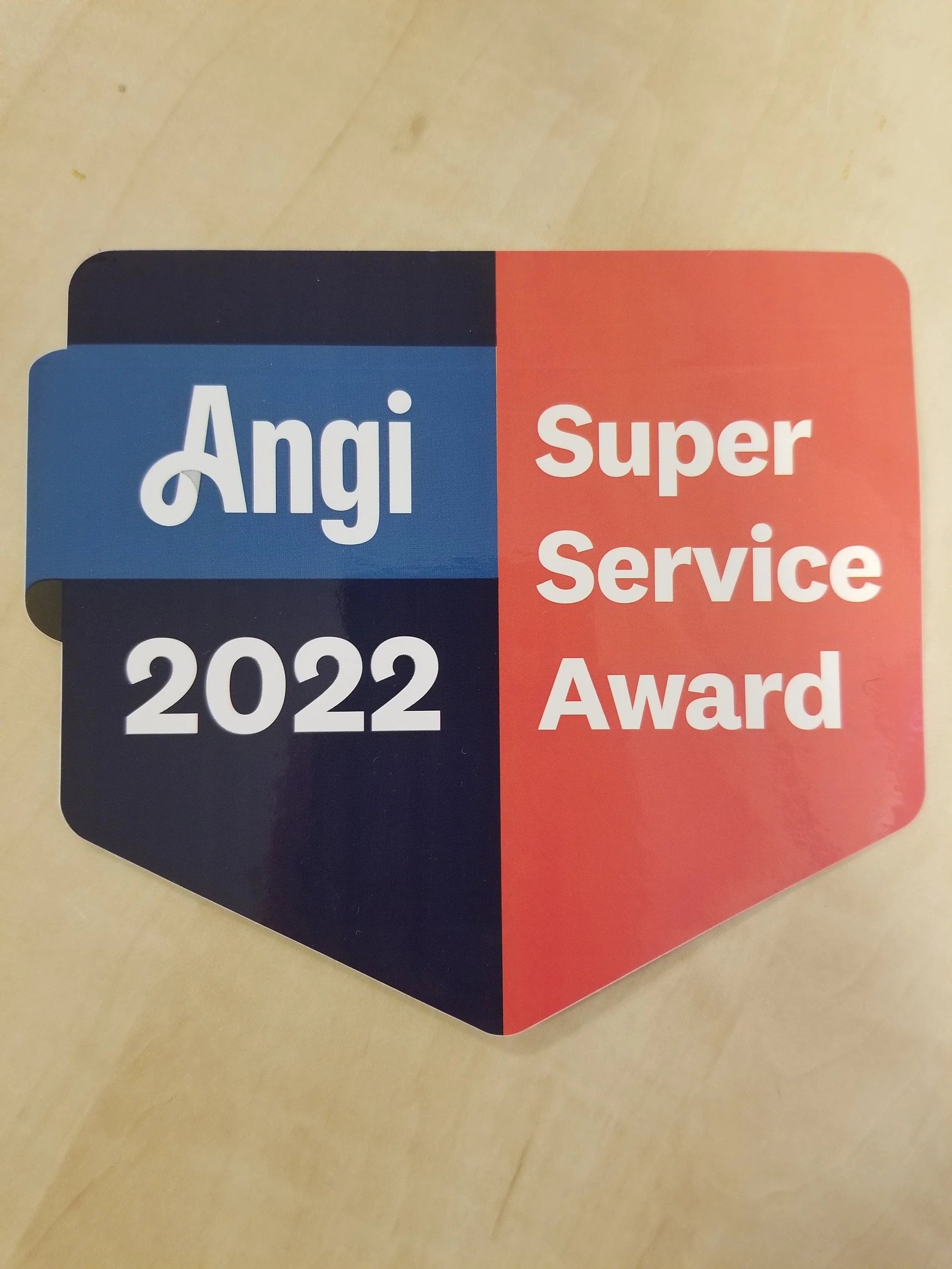 Colorful award badge with blue, black, and red sections, displaying the text 'Angi', '2022', and 'Super Service Award'.