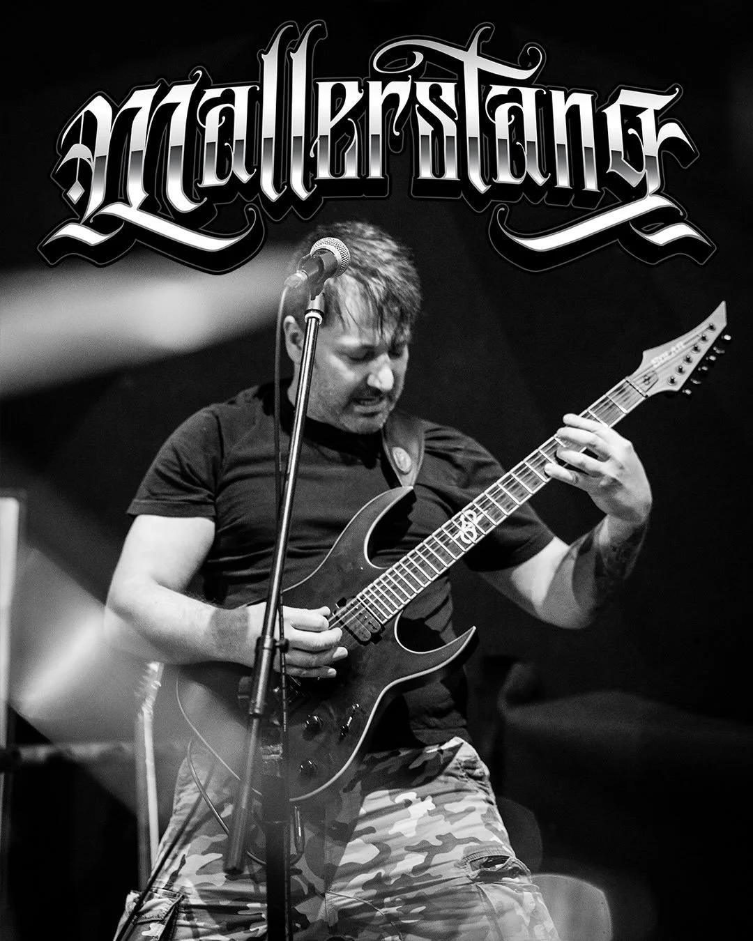 Black and white photo of a man passionately playing an electric guitar on stage, with the word 'Metal스타인' displayed prominently at the top.