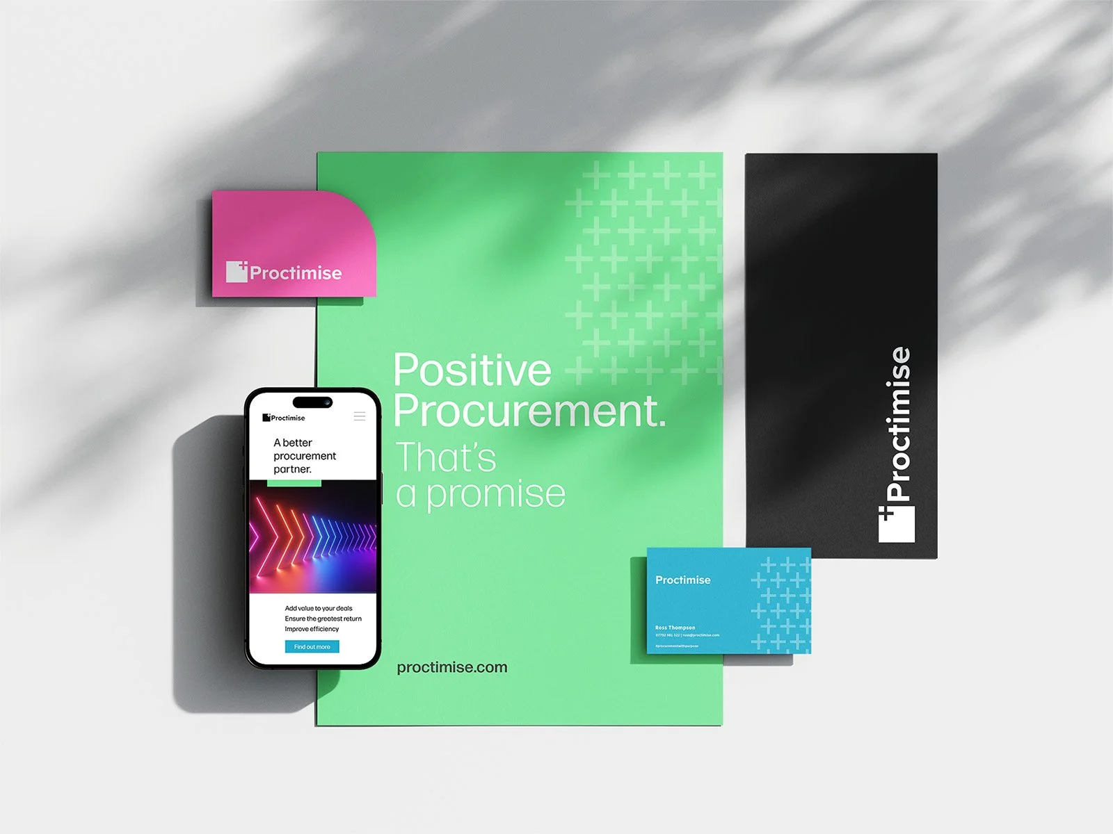 Arrangement of branded marketing materials for Proctimise including a large green poster with the slogan 'Positive Procurement. That's a promise,' a black banner with the logo, a blue business card, and a smartphone displaying a webpage for Proctimis