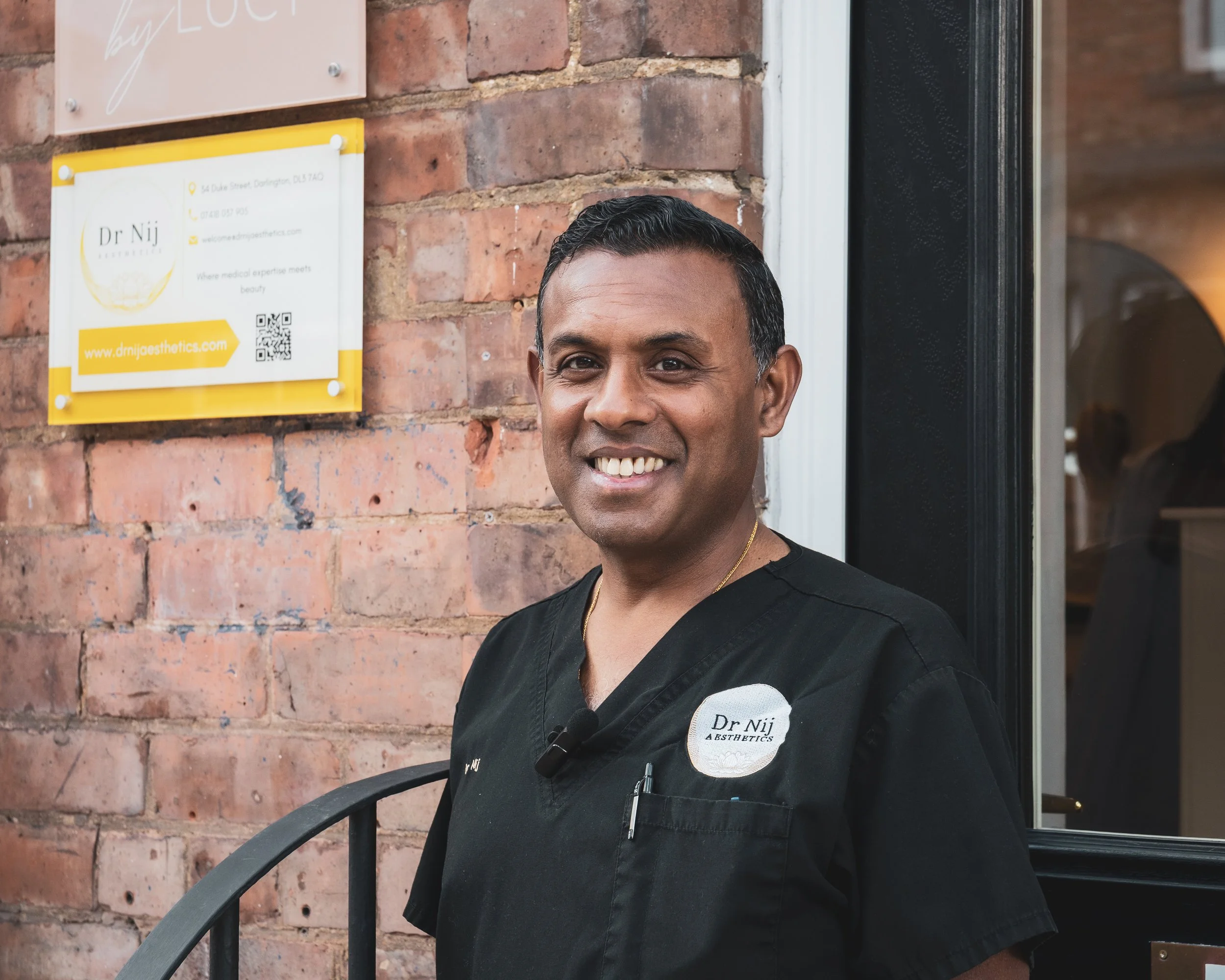 Professional portrait of an aesthetics practitioner standing outside a clinic in Darlington.